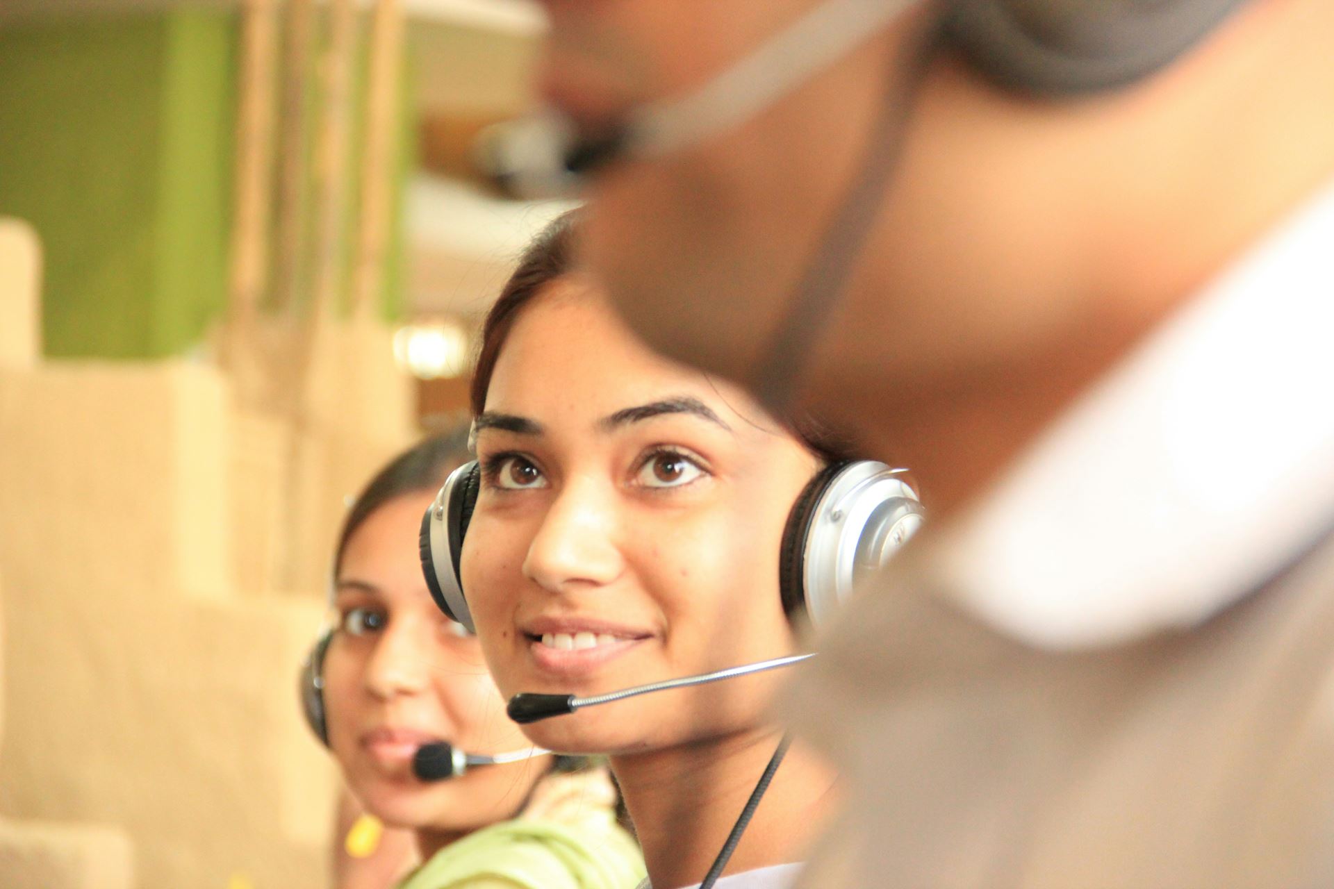 A row of people with headsets on answering calls