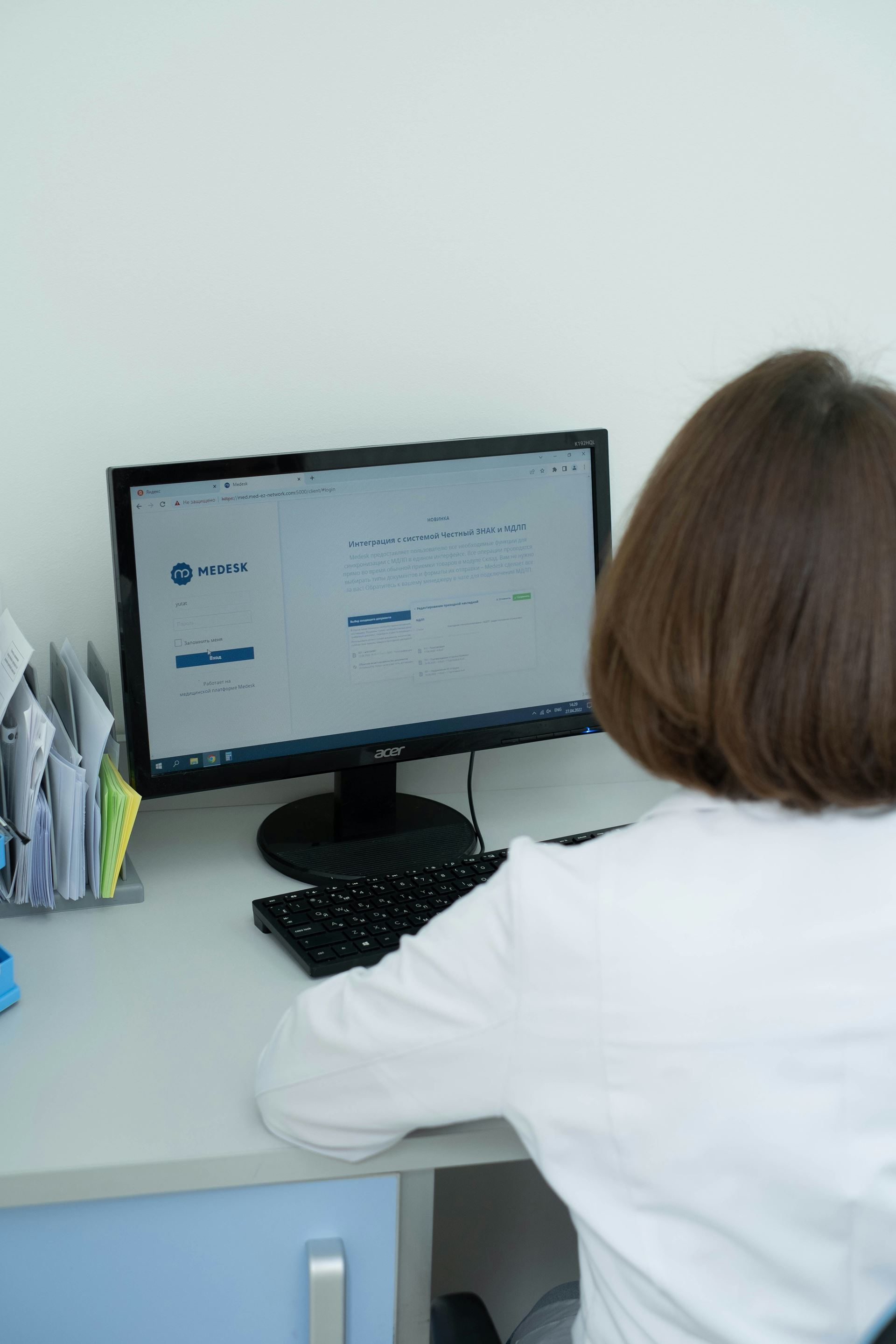 A woman sitting at a desk and using the computer