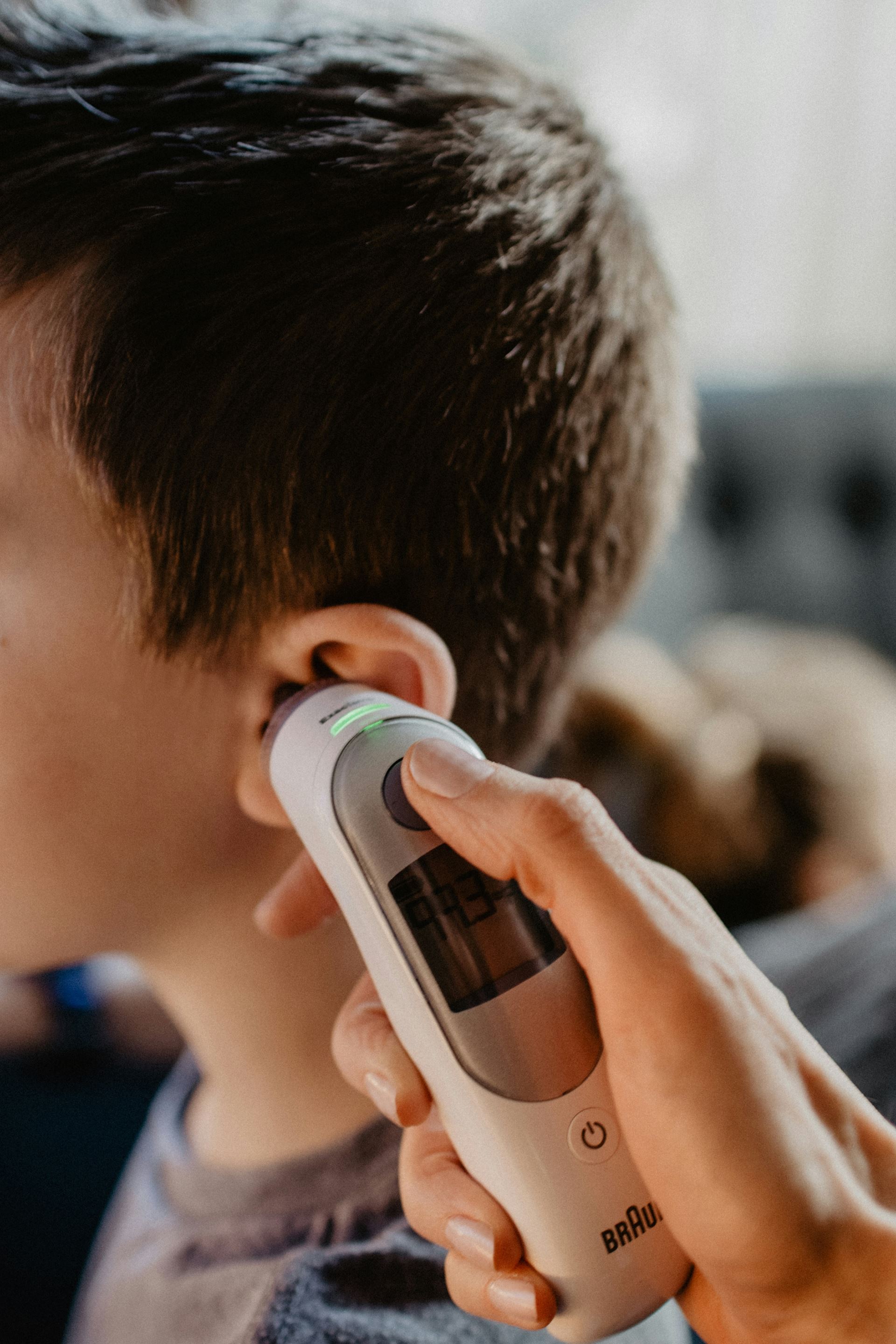 A person having their temperature taken with a thermometer in their ear