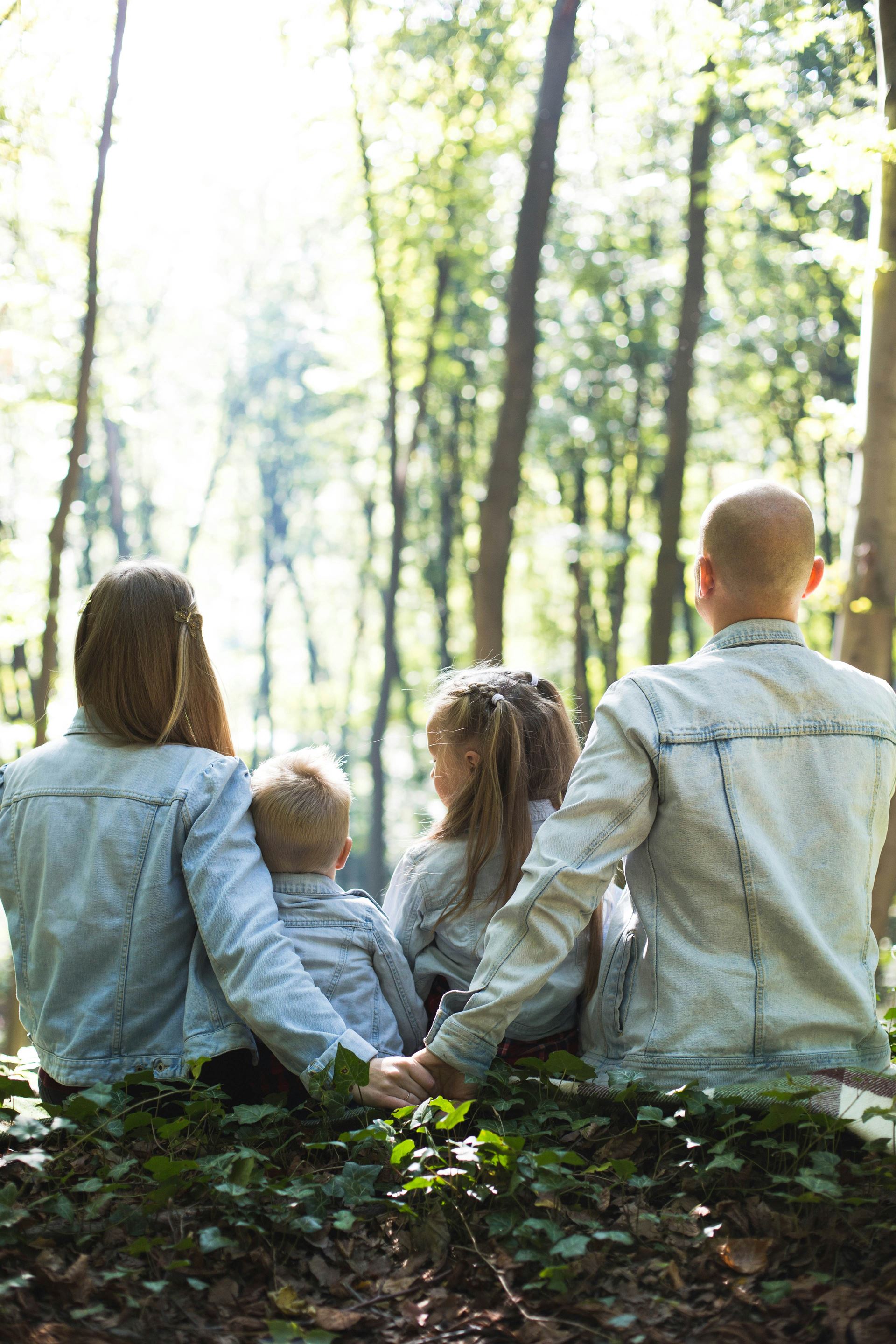 A family outdoors in a forest on a sunny day